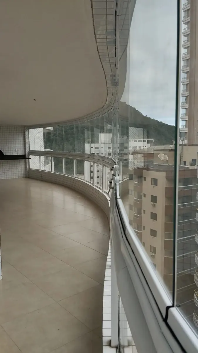 Envidraçamento de sacada curva com vista para o morro no litoral sul SP