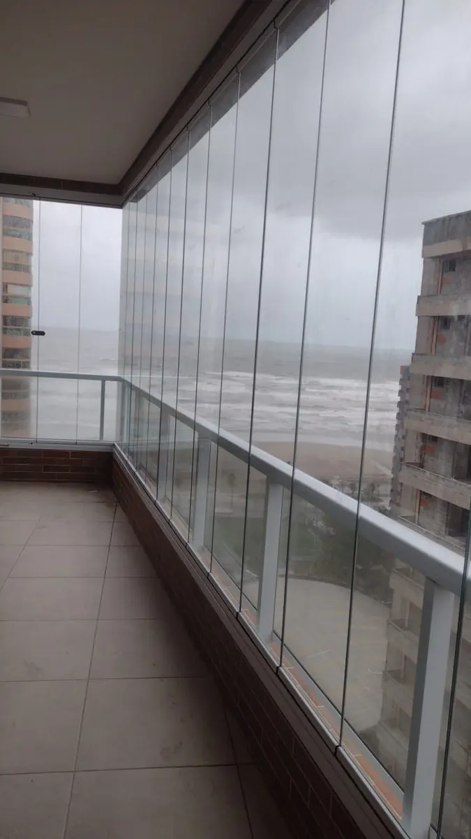 Sacada envidraçada protegida da chuva em frente à praia